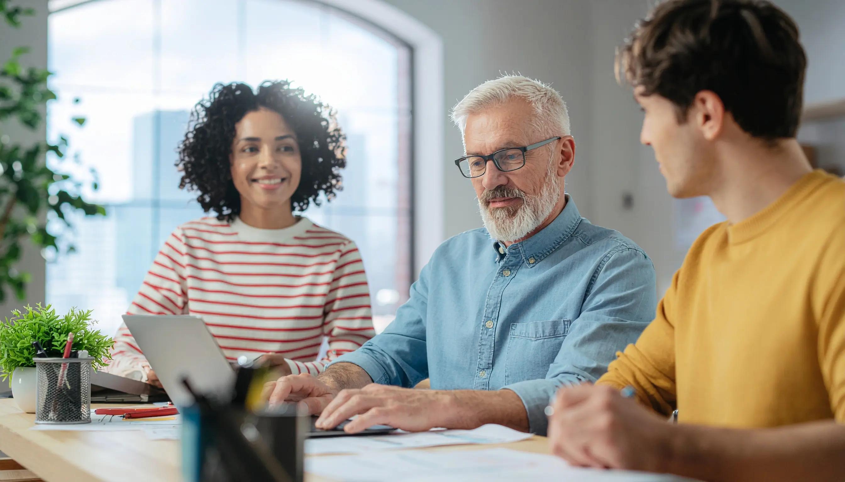 Das Bild zeigt ein vielfältiges Team, das gemeinsam an der App-Entwicklung arbeitet und verschiedene Phasen wie Design, Planung und Implementierung veranschaulicht. Sie diskutieren über App-Konzepte und Projektmanagement und legen Wert auf Teamarbeit bei der Entwicklung innovativer mobiler und Web-Apps.